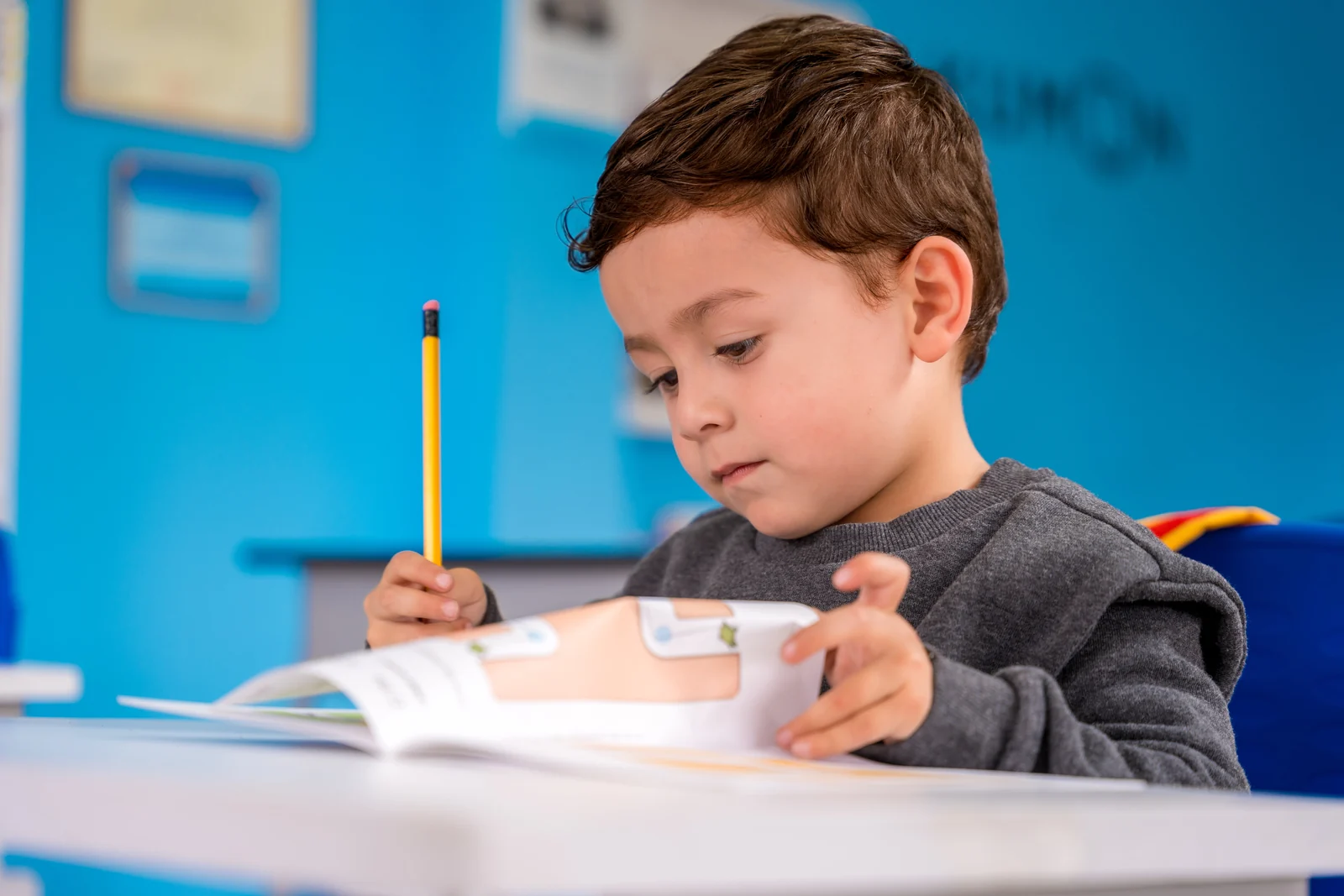 Criança praticando escrita com o material do Kumon